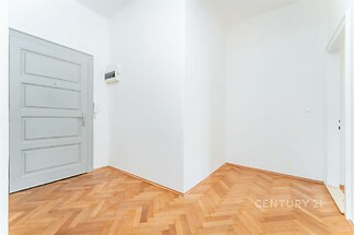 Vstupní hala s parketovou podlahou, bílé stěny, moderní design a dostatek prostoru pro vestavěné skříně.