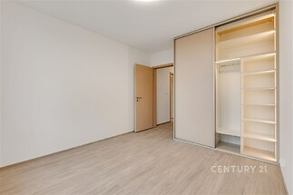 Ložnice s vestavěnou šatní skříní s osvětlením.