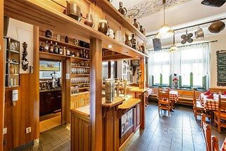 Restaurace v rustikálním stylu nabízí dřevěný interiér s dlažbou, velká okna s přirozeným světlem a tradiční dekorace.
