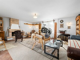 Světlý obývací pokoj s krbovými kamny, dlažba a parketová podlaha, rustikální styl.