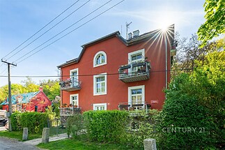 Zrekonstruovaný cihlový dům se zahradou, moderní fasáda, balkony, okna s bílými rámy, klidná lokalita, ideální investice do bydlení