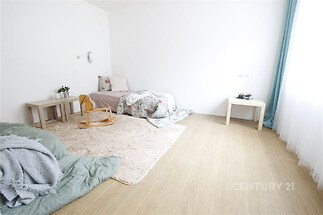 Světlý dětský pokoj s dřevěnou podlahou, velká okna s modrými závěsy, moderní design.