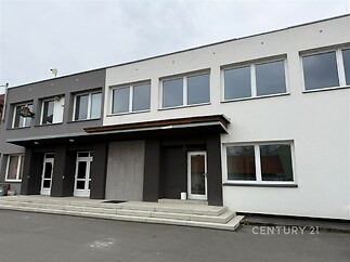 Moderní fasáda komerční budovy s velkými okny a elegantním vstupem, nově rekonstruovaný objekt v atraktivní lokalitě