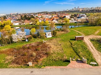 Stavební pozemek poblíž vodní plochy s výhledem na sousedství, vhodný pro výstavbu rodinného domu, klidná lokalita, blízkost přírody.