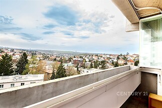 Prostorný zasklený balkon s panoramatickým výhledem, vhodný pro relaxaci, nabízí klid a soukromí ve vyhledávané lokalitě.