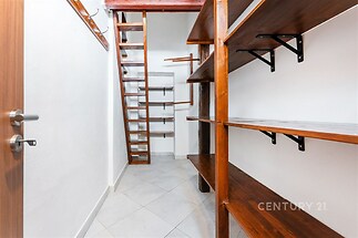 Úložný prostor s dřevěnými policemi, dlažbou a moderním designem. Světlý interiér nabízí dostatek místa pro uskladnění věcí.