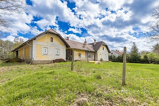 Historická venkovská chalupa s původní fasádou, šikmou střechou a rozsáhlou zahradou, vhodná k rekonstrukci, obklopená přírodou.