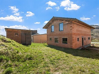 Řadový rodinný dům v rekonstrukci, cihlová fasáda bez omítky, umístěný na prostorném pozemku s travnatou plochou, slunná lokalita s krásným výhledem