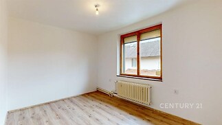 Světlá ložnice s laminátovou podlahou, velkým oknem a čerstvě vymalovanými stěnami ve světlých tónech optimalizuje prostor pro moderní bydlení.