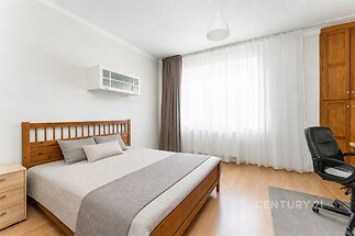 Prostorná ložnice s parketovou podlahou, velkým oknem a vestavěnou skříní, moderní a dobře osvětlená, nabízí pohodlné bydlení.