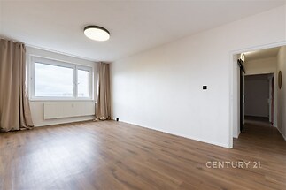 Světlý obývací pokoj, parketová podlaha, velká okna, moderní styl, neutrální barvy, prostorný interiér, vhodný pro rodiny.