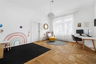 Dětský pokoj s parketovou podlahou, velká okna poskytují světlé, moderní prostředí, ideální pro hru a práci, dekorativní malby na stěnách.