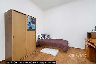 Jednoduchá ložnice s parketovou podlahou, vestavěnou skříní a minimalistickým vybavením. Světlý interiér nabízí prostor pro kreativitu.