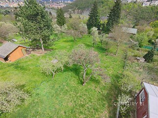 Zahrada s ovocnými stromy nabízí rekreační prostor v přírodě. Výhled do údolí, mírný svah a klidné okolí přidávají na atraktivitě pozemku.