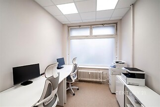 Malá kancelář s koberci, moderním nábytkem a velkým oknem, které zajišťuje dostatek přirozeného světla.