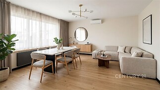 Světlý obývací pokoj s parketovou podlahou, moderním nábytkem a velkými okny, které poskytují dostatek přirozeného světla.