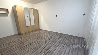 Ložnice s moderní laminátovou podlahou, velká okna s bílými závěsy, prostorná vestavěná skříň, světlý a čistý interiér