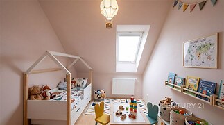 Dětský pokoj s dřevěnou podlahou, světlými stěnami a střešním oknem. Moderní design s hračkami a dekoracemi.