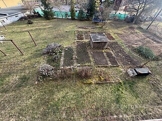 Prostorná zahrada s rekreačním přístřeškem, ideální pro pěstování. Travnatá plocha s možností vlastní úpravy, dobrý potenciál pro zahradničení.