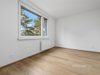 Světlá ložnice, parketová podlaha, velká okna zajišťující dostatek přirozeného světla, moderní a čistý interiér.