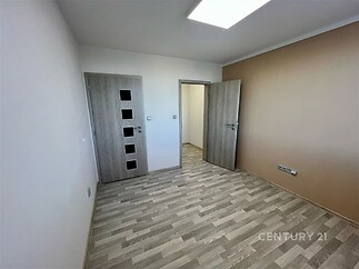 Prázdná ložnice s parketovou podlahou, moderní dveře s prosklením a bílými stěnami, vhodná pro rekonstrukci a individuální úpravy.