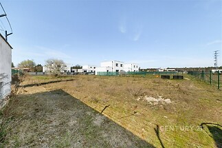 Prázdný stavební pozemek s rovným terénem, oplocený, v klidné lokalitě, připravený pro výstavbu, ideální pro rodinný dům.