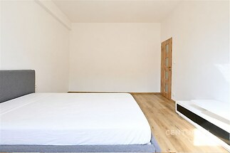 Prostorná ložnice s parketovou podlahou, moderní vestavěné skříně a velká okna zajišťují dostatek přirozeného světla.