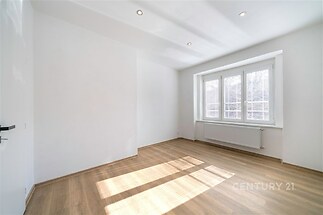 Světlá ložnice s parketovou podlahou, velká okna zajišťují dostatek přirozeného světla, moderní úprava interiéru vhodná k nastěhování.