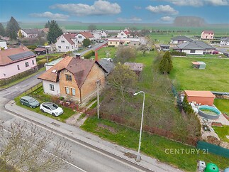 Rodinný dům s cihelnou fasádou, umístěný v klidné vesnické lokalitě. Velká zahrada s bazénem, blízkost přírody a prostorný pozemek.
