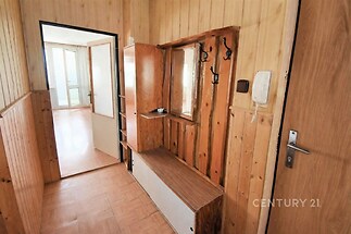 Předsíň s dřevěným obložením, parketovou podlahou a vestavěným nábytkem; světlý prostor s praktickým úložným řešením.