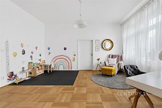 Dětský pokoj s parketovou podlahou, velká okna zajišťují světlost, stylově zařízený prostor s moderním nábytkem a dekoracemi pro děti.