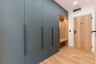 Vstupní hala s vestavěnými skříněmi, moderní design, laminátová podlaha, dřevěné dveře.