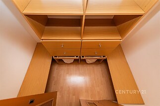 Šatna s vestavěnými skříněmi, parketovou podlahou a dřevěným povrchem nabízí moderní úložný prostor.