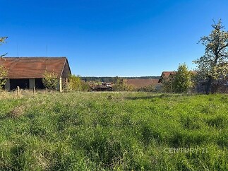 Prostorná zahrada s výhledem na okolní krajinu, zástavba s dřevěnou střechou, klidná lokalita, možnosti výstavby nebo rekreace.