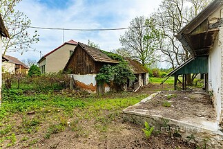 Zahrada u venkovského domu s oplocením, zanedbaný stav, potenciál pro rekonstrukci, klidná lokalita obklopená přírodou.