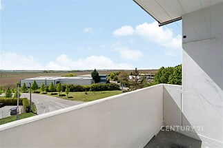 Prázdný balkon s výhledem na okolní krajinu, minimalismus, čisté linie, klidná lokalita, vhodné pro relaxaci.
