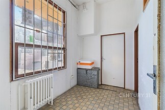 Vstupní hala s dlažbou, velkým oknem a bílými stěnami, nabízí prostor pro úložné řešení, vhodná pro renovaci.