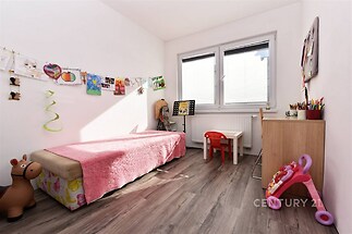 Dětský pokoj s laminátovou podlahou, světlými stěnami a velkými okny poskytuje moderní a útulný prostor.