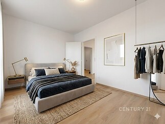 Světlá ložnice s moderním stylem, parketová podlaha a vestavěné skříně, minimalistický design, dekorativní obrazy na stěnách.