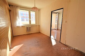 Světlý obývací pokoj s dřevěnou podlahou, velkými okny a světlým stěnovým obkladem, ideální pro moderní uspořádání.