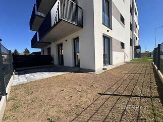 Předzahrádka s dlažbou a trávníkem, moderní novostavba, balkon a velká okna, klidné prostředí.