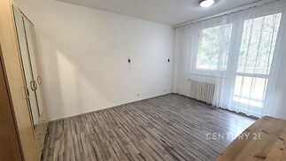 Světlá ložnice s velkými okny, laminátová podlaha, vestavěné skříně, moderní styl a přímý přístup na balkon