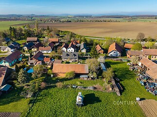 Malebná venkovská usedlost s rozlehlým pozemkem, tradiční stavení a zemědělské budovy, klidná lokalita obklopená přírodou, ideální pro venkovské bydlení.