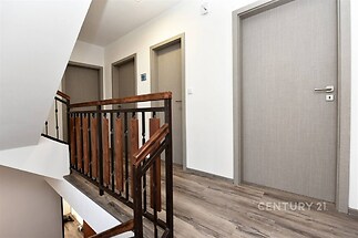 Chodba s dřevěným zábradlím a světlou podlahou, moderní dveře vytvářejí elegantní vzhled, rekonstrukce v nadstandardním provedení