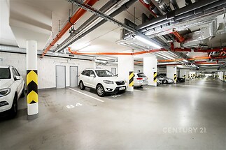 Podzemní garáž s hladkou betonovou podlahou, moderní osvětlení, vyznačená parkovací místa, bezpečné prostředí