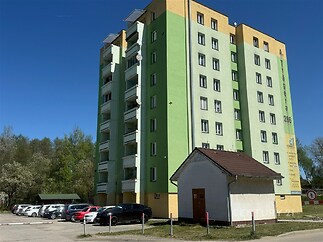 Vícepodlažní bytový dům s barevnou fasádou, parkování před budovou, klidná lokalita, dobrý stav.