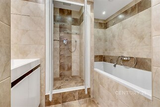 Koupelna s XXL vanou a sprchovým boxem.