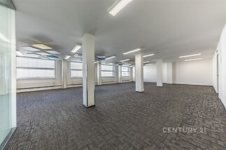 Prostorná komerční kancelář s moderním kobercem, vestavěnými světly a velkými okny poskytujícími dostatek přirozeného světla