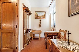 Tradiční vstupní hala s dřevěným nábytkem, parketová podlaha, dekorativní prvky a světlé stěny.
