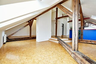 Podkrovní prostor s dřevěnými trámy, světlými stěnami a parketovou podlahou, moderní interiér, otevřený design, optimální prosvětlení